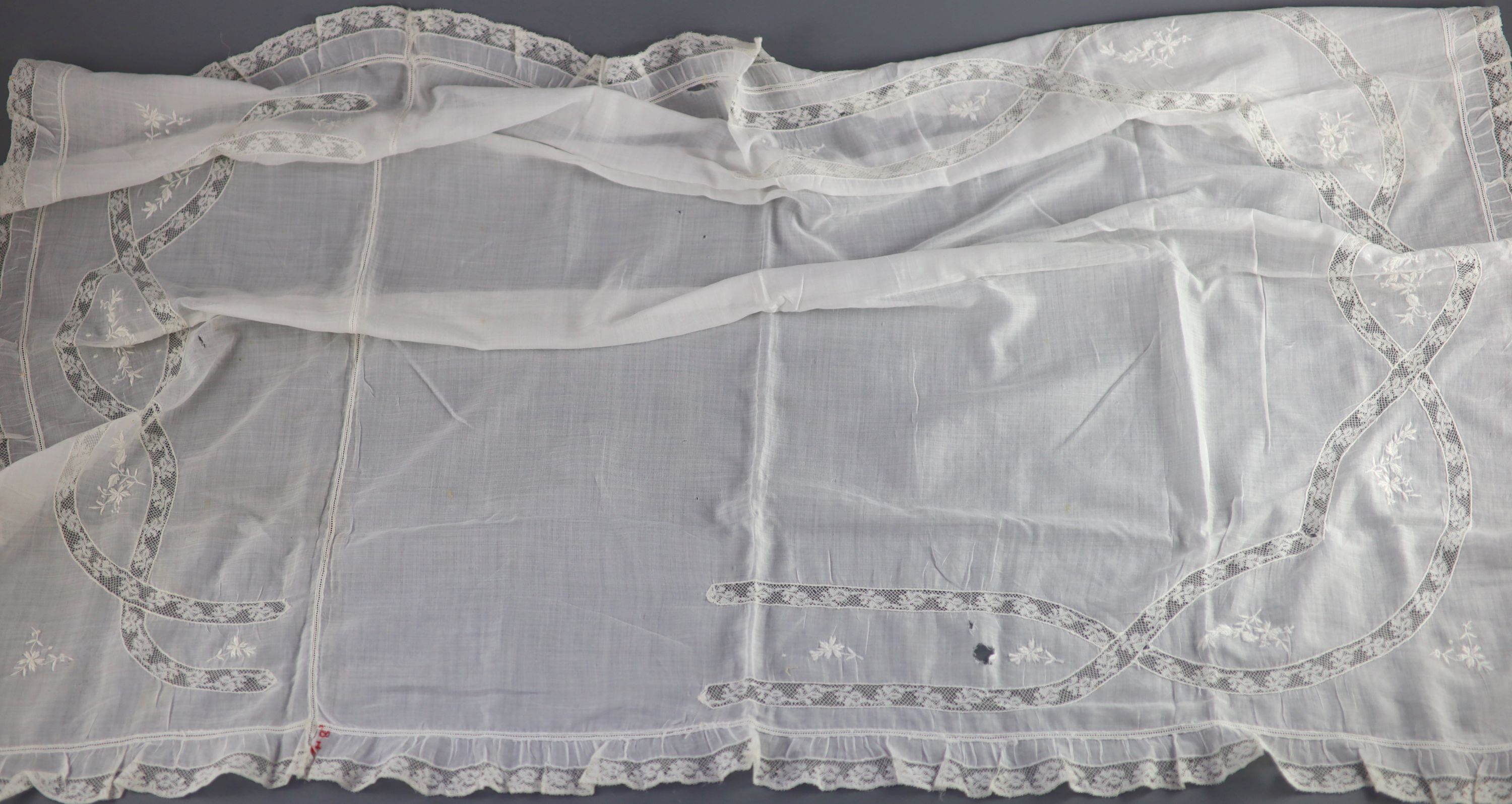 A fine white worked embroidered lace inset coverlet, a filet lace square of a figure wearing a crown (plus museum note),